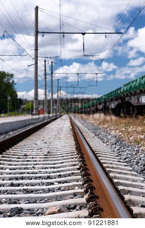 Rails And Railway Sleepers With Clouds In A Bright Blue Sky