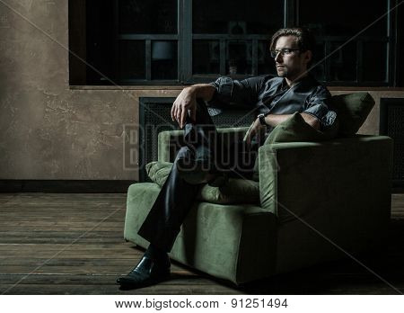 Businessman sitting on an armchair. Fahion man.