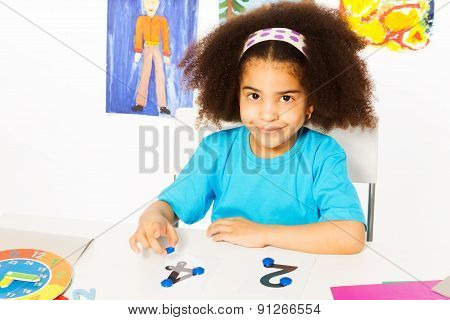Cute African girl learn numbers with coins