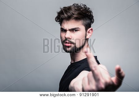 Young man in  black T-shirt showing middle finger