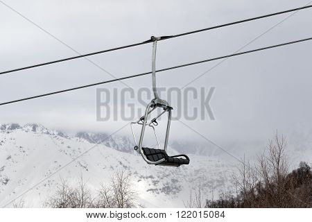 Chair Lift And Snowy Mountains In Haze