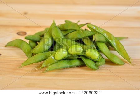boiled green soybeans with shell on wooden table