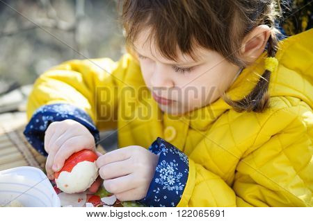 Beautiful little girl with pigtails and a yellow jacket from the clean egg shell red