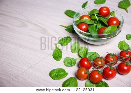 Salad With Spinach And Tomatoes And Copy Space On Wooden Table