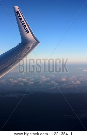WARSAW - AUGUST 08: Looking through window aircraft Ryanair during flight in wing on August 08 2015. Ryanair is one of the largest low-cost European airline by scheduled passengers carried.