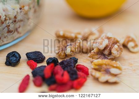 Ingredients for a salad with delicious fresh quinoa and bulgar weat with parsley walnuts goji berries and blue berries sprinked with olive oil and lemon juice