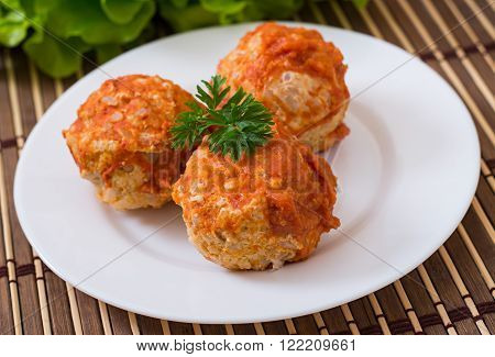 Meatballs in tomato sauce on a white plate