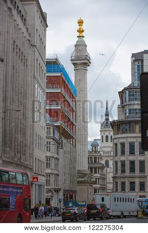 LONDON, UK - SEPTEMBER 19, 2015: City of London street with Monument, traffic and people crossing the road