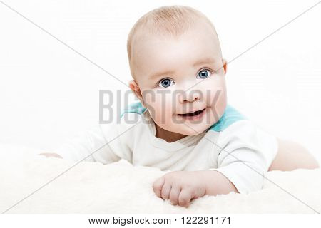 A cropped shot of an adorable baby boy lying on a blanket.Close up headshot of a caucasian baby boy.