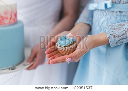 Woman holding one blue cupcake, close up