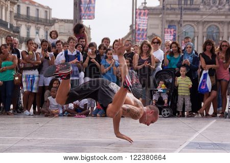 Montpellier, France - July 12: Street performer breakdancing on main square in front of the random crowd on July 12, 2011 in Montpellier, France.