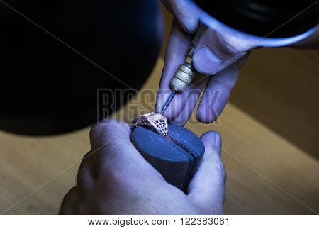 Jeweler working and crafting jewelry in a yard