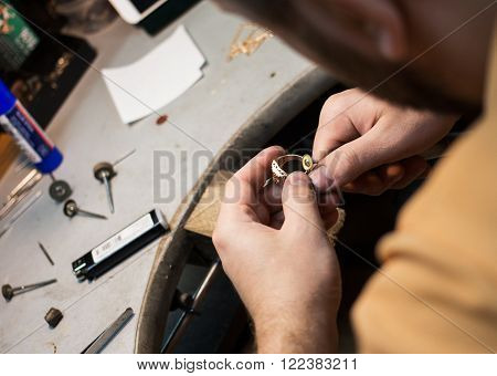 Jeweler working and crafting jewelry in a yard