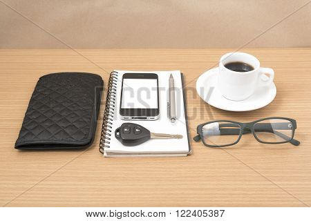 coffee and phone with notepad carkey eyeglasses and wallet on wood table background