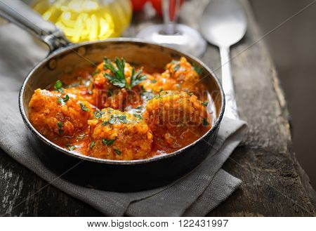 meatballs in tomato sauce, a fork and a spoon on a wooden background
** Note: Shallow depth of field