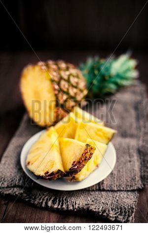 Pineapple tropical fruit / Ananas with slices over wooden table / Rustic country style