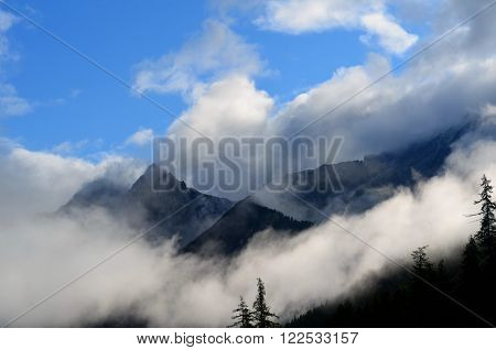 Morning mist in the mountains. The silhouettes of the mountains look mystical