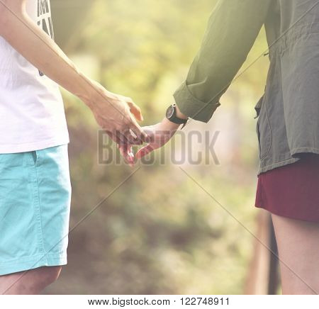 Women and men Happy couple holding hands in the sunset.sofe light effect