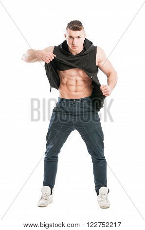 Young and handsome male model showing abs by ripping his shirt on white background