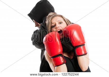 Male aggressor grabbing a frightened woman wearing boxing gloves. Female victim concept on white background
