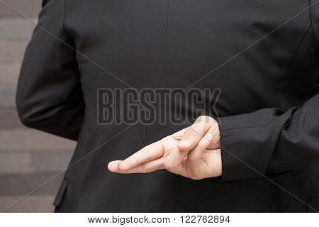 Dishonesty Business fraud concept Businessman showing fingers crossed