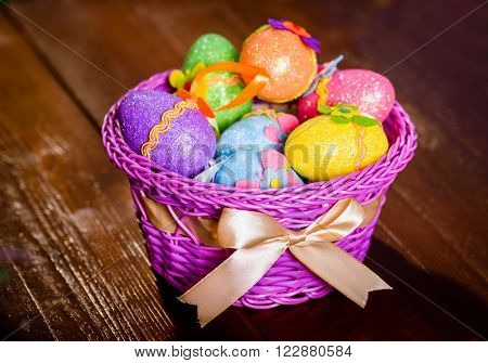 easter eggs in violett basket on wooden background