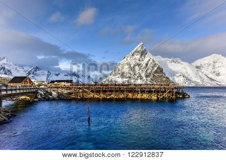 Fishing hut (rorbu) in the Hamnoy and Lilandstinden mountain peak in winter in Reine, Lofoten Islands, Norway.