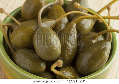 Bowl with pickled caperberries close up