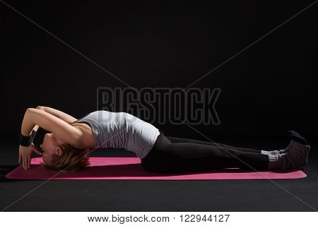 Young woman practicing yoga, Matsyasana / Fish pose