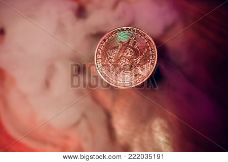 Burning symbol of bitcoin with man in the background. Conception of risk management in money trading at currency market