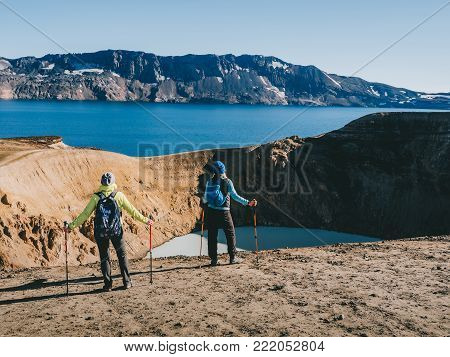 hikers looking at Geothermal crater lake near the Askja volcano, Iceland