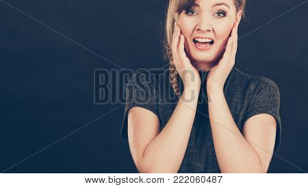 Fear and shock concept. Young expressive blonde shocked scared woman. Afraid surprised confused girl in gray.