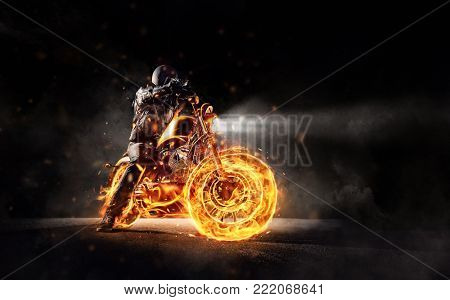 Dark motorbiker staying on burning motorcycle, separated on black background. Dark art wallpaper photo of chopper motorbike. Very high resolution image