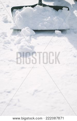 a person using a snow shovel to remove snow.