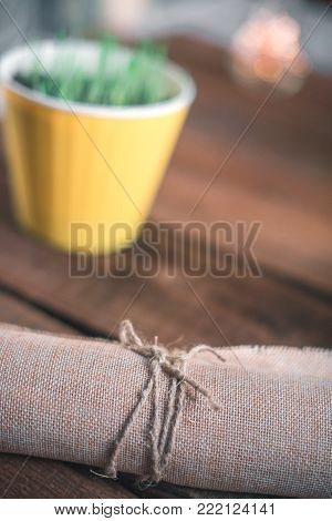 Pot in a pot on a wooden background with burlap-bound