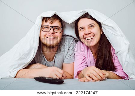 man with woman watchin comedy movie under the blanket