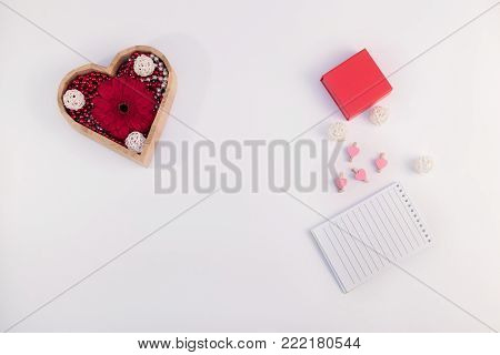 wooden box heart shape with beads and flower gerberas and red box and other items on a white background