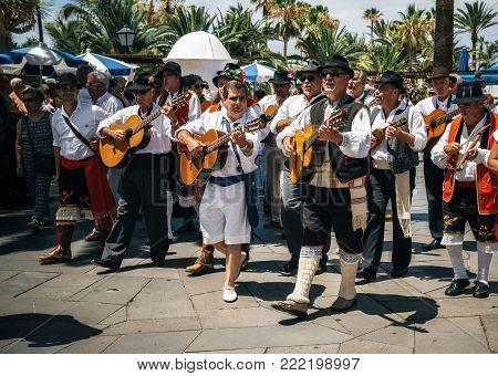 Puerto de la Cruz, Tenerife, Canary Islands - May 30, 2017: Canaries people dressed in traditional clothes walk along the street, sign and play guitars. Local residents of Tenerife celebrate the Day of the Canary Islands.