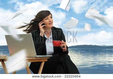 businesslady avec ordinateur portable fonctionne à côté d'un lac. Papier vole autour. Mot clé unique pour ce c