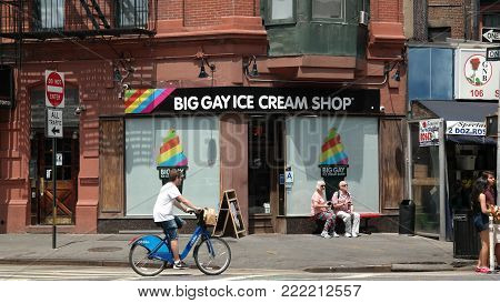 New York City, New York, USA 05.29.2016 male person on city bike passing storefront of Big Gay Ice Cream Shop near Christoper Street Station
