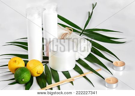 White bottles and two whole lemon and lime isolated on white background. The concept for advertising cosmetics. Still life. Copy space