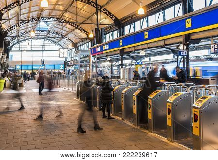 Nijmegen, Netherlands - November 7, 2017: OV-gates at railway central station Nijmegen with travellers and trains at the platform.
