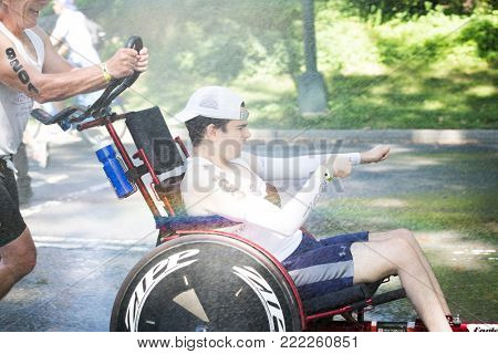 NEW YORK - JUL 16 2017: David and Blake Ferrell, a father and son team, run through a spray of water during 10k run portion of the NYC Triathlon Race in Central Park.