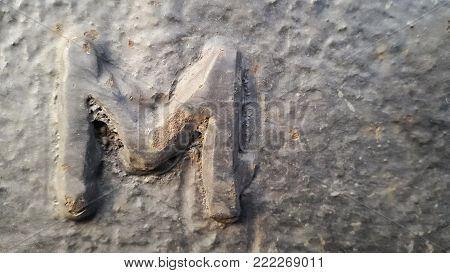 Metal latter M. Texture of rusty metal in the form of latter M.