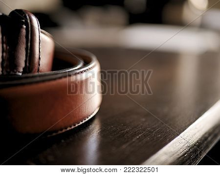 Brown Leather Belt on Wooden Desk with Bokeh