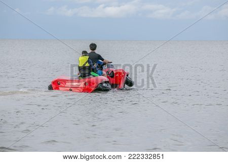 A man and his son driving amphibious car into the sea