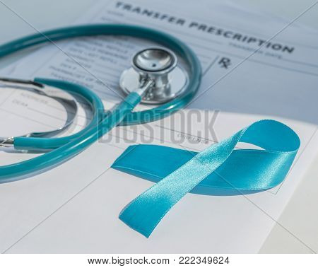 Blue ribbon symbolic of prostate cancer awareness campaign and men's health in November month on  patients health record  form with doctor stethoscope.