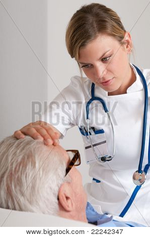 古い患者と病院でのインフルエンザのチェックの若い看護師の世話の笑みを浮かべてください。