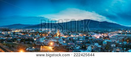 Gori, Shida Kartli Region, Georgia. Panoramic Cityscape In Bright Yellow Evening Illumination Under Blue Sky In Autumn Twilight.  Aerial View Of City. Travel Destination In Night Illuminations Lights.