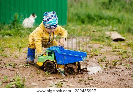 the boy in the street playing with a toy car